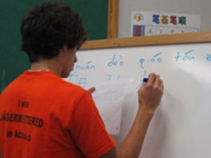a male student writes on a whiteboard