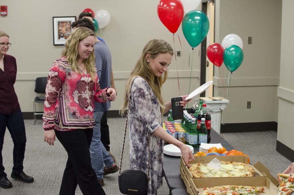 students help themselves to pizza at an Italian Club event